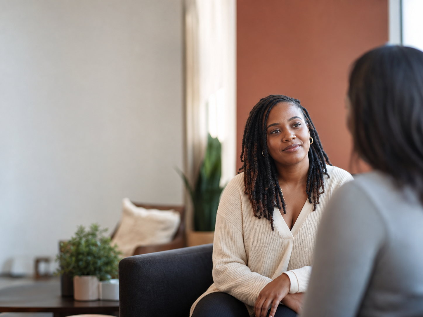A woman speaking with a compassionate care professional in a warm, welcoming room.